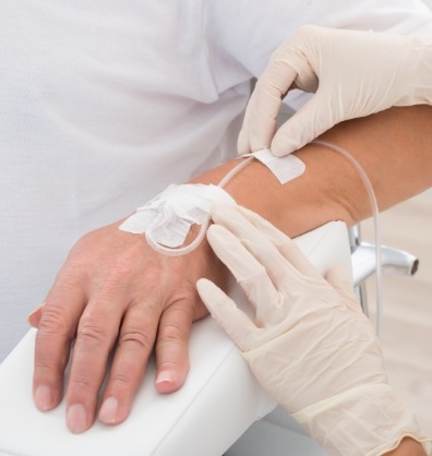 Dental team member adjusting an I V in a patients arm