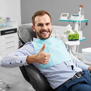 Male patient in dental chair giving thumbs up