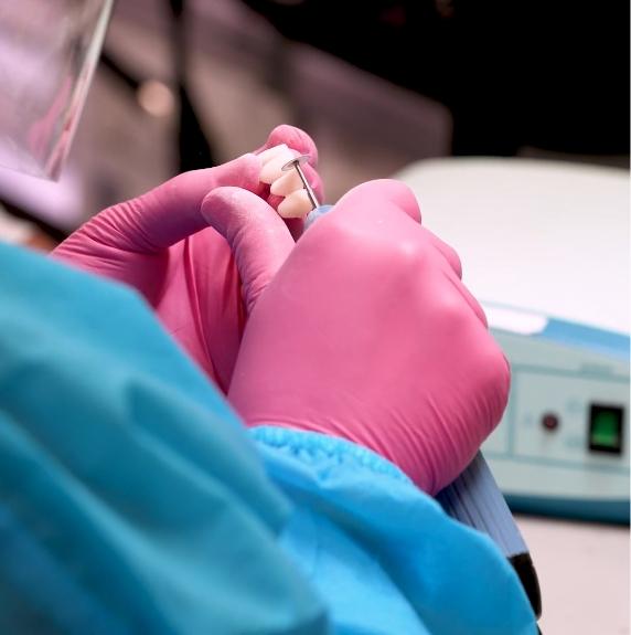 team member refining dental implants