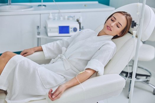 Patient receiving IV sedation looking relaxed in treatment chair