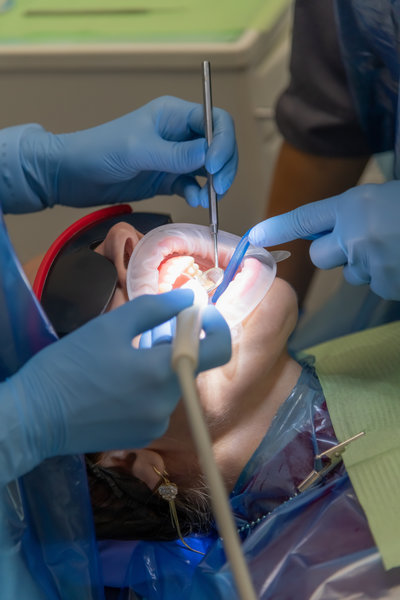 Woman receiving dental treatment in a clinic with professionals assisting her